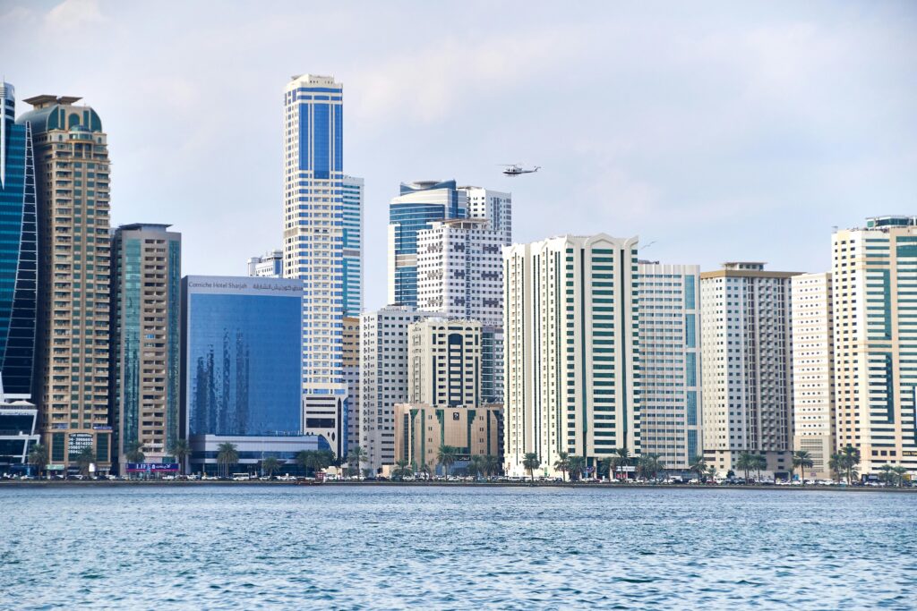 A view of Sharjah's modern skyline with tall skyscrapers and waterfront setting, showcasing the city's urban development.